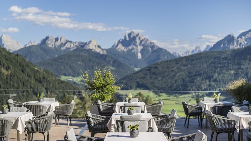 Le foto più belle dell’Alpen Tesitin Terrazza con tavoli apparecchiati e vista sulle montagne in giornata di sole