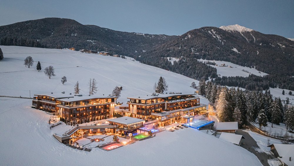 Le foto più belle dell’Alpen Tesitin Hotel illuminato in paesaggio montano innevato al crepuscolo
