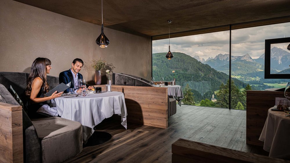 Le foto più belle dell’Alpen Tesitin Coppia cena in ristorante con vista sulle montagne verdi e valle