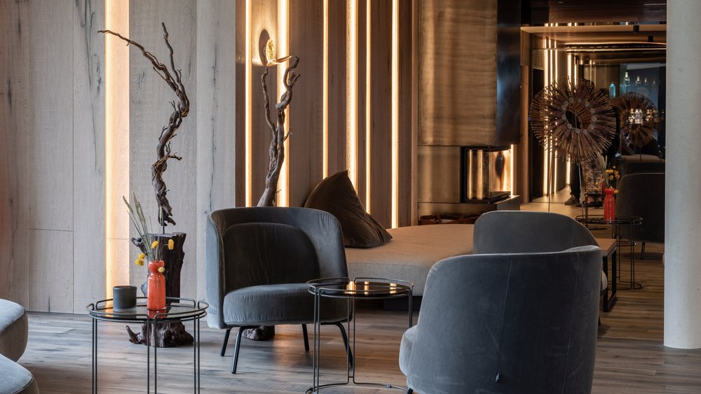 Le foto più belle dell’Alpen Tesitin Area soggiorno moderna con poltrone grigie e illuminazione accogliente