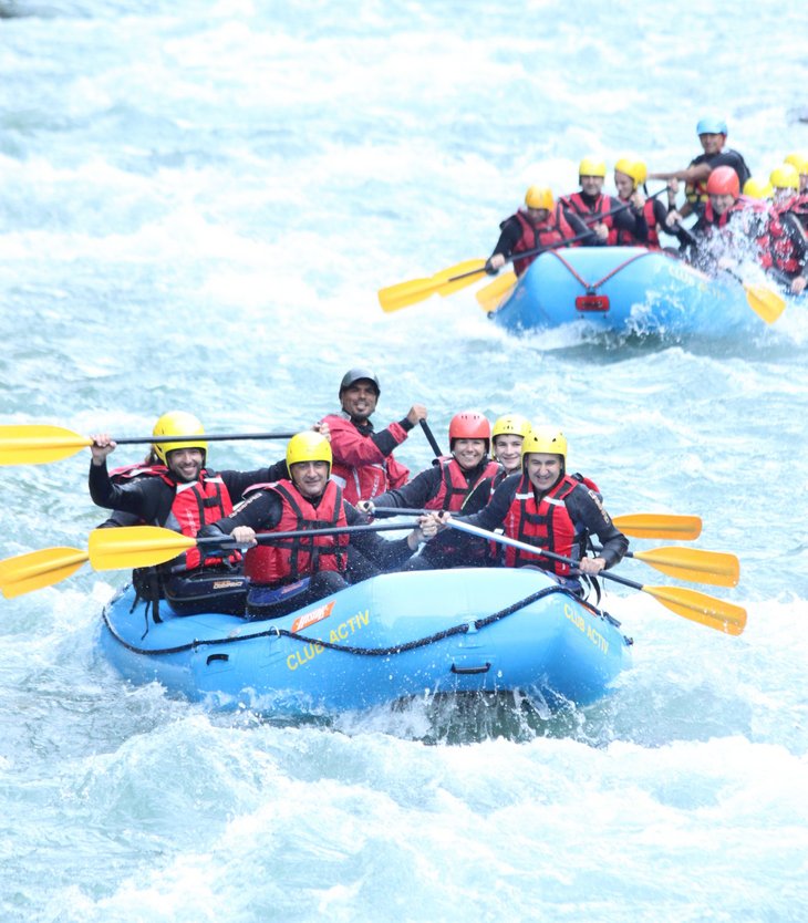 Action & adventure in Alta Pusteria/Hochpustertal People white water rafting on a river wearing helmets and paddles