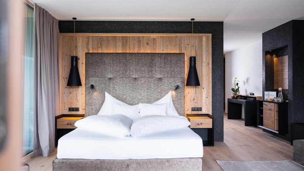 Le foto più belle dell’Alpen Tesitin Camera da letto moderna con letto confortevole e parete in legno