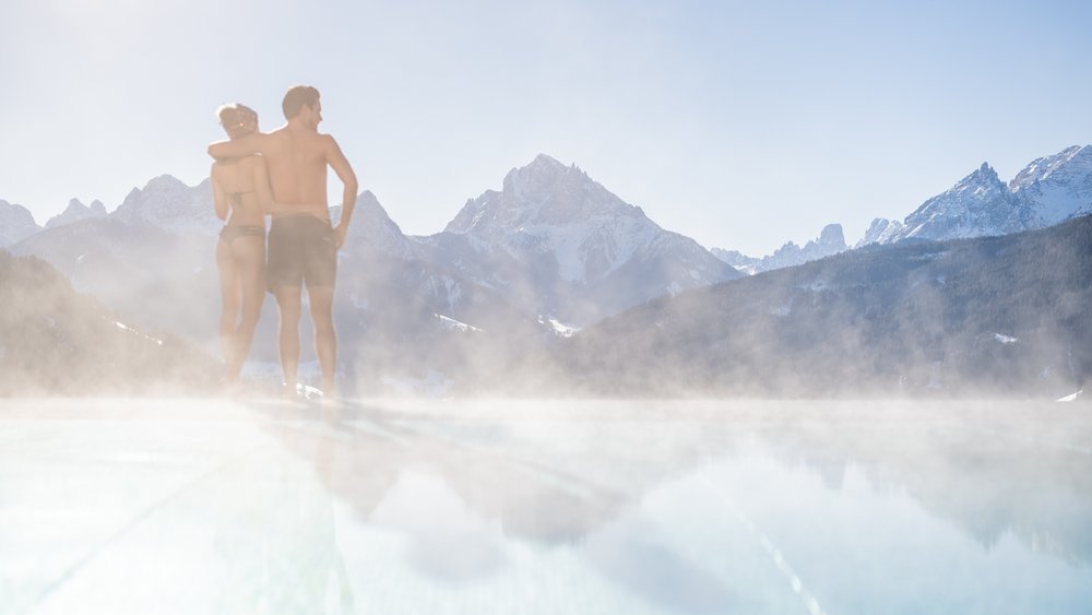 Le foto più belle dell’Alpen Tesitin Coppia in piscina con vista sulle montagne e nebbia in clima freddo
