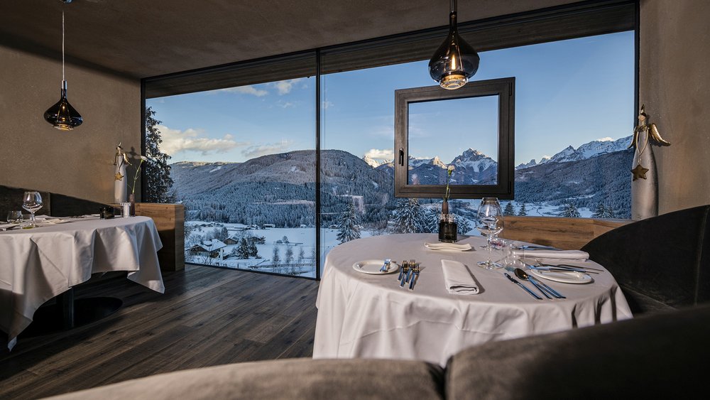 Le foto più belle dell’Alpen Tesitin Ristorante con vista sulle montagne innevate e tavoli con tovaglie bianche