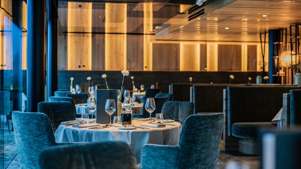 Le foto più belle dell’Alpen Tesitin Ristorante elegante con tavoli apparecchiati e luce soffusa