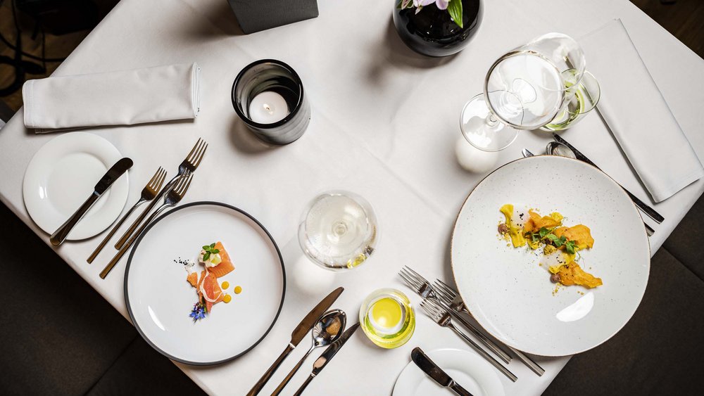 Le foto più belle dell’Alpen Tesitin Tavola elegante apparecchiata con piccoli piatti gourmet e bicchieri da vino