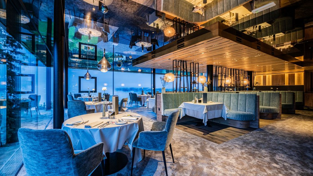 Le foto più belle dell’Alpen Tesitin Ristorante moderno con sedie blu e grandi finestre panoramiche