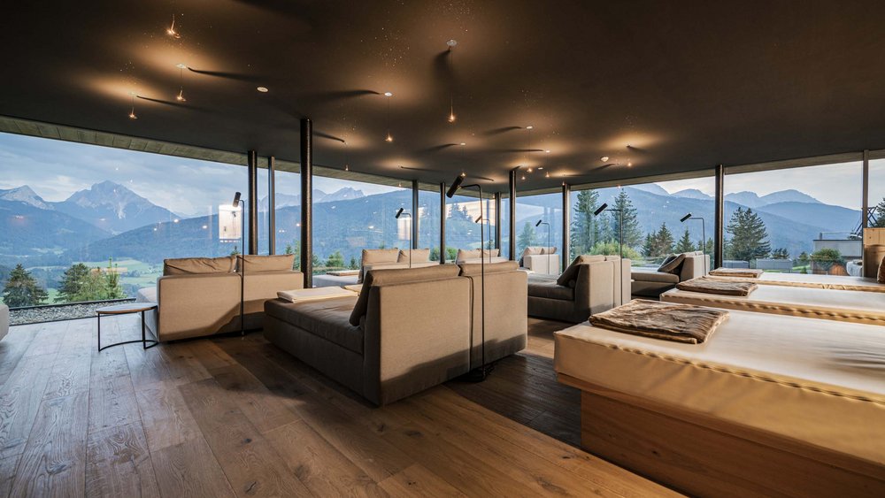 Le foto più belle dell’Alpen Tesitin Lounge moderna con divani comodi e vista panoramica su montagne e foresta