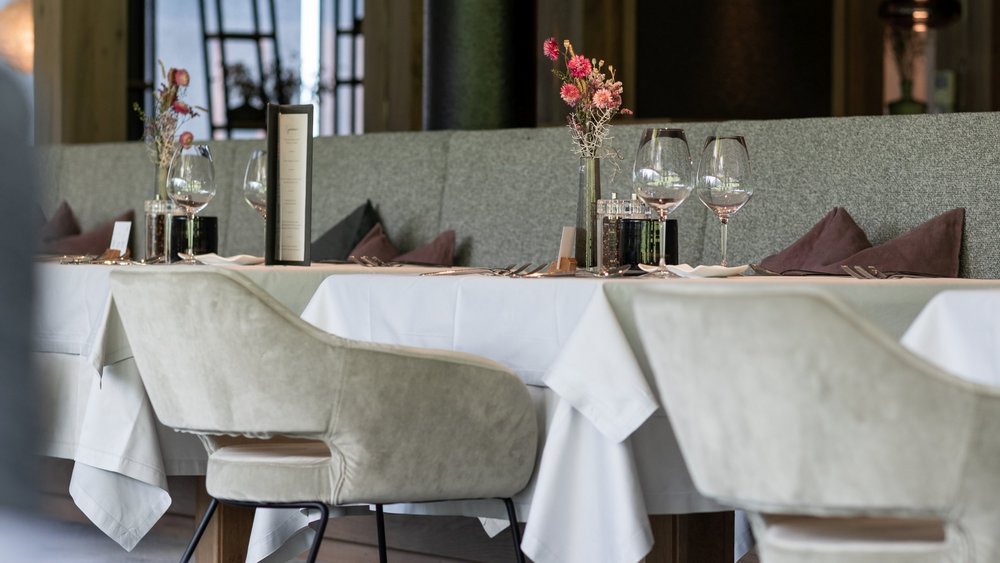 Le foto più belle dell’Alpen Tesitin Ristorante elegante con tavoli apparecchiati e sedie moderne