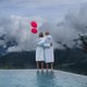 Ihr Hotel im Pustertal mit 5 Sternen: Alpen Tesitin Paar in Bademänteln mit zwei roten Luftballons an einem Pool vor nebligen Bergen