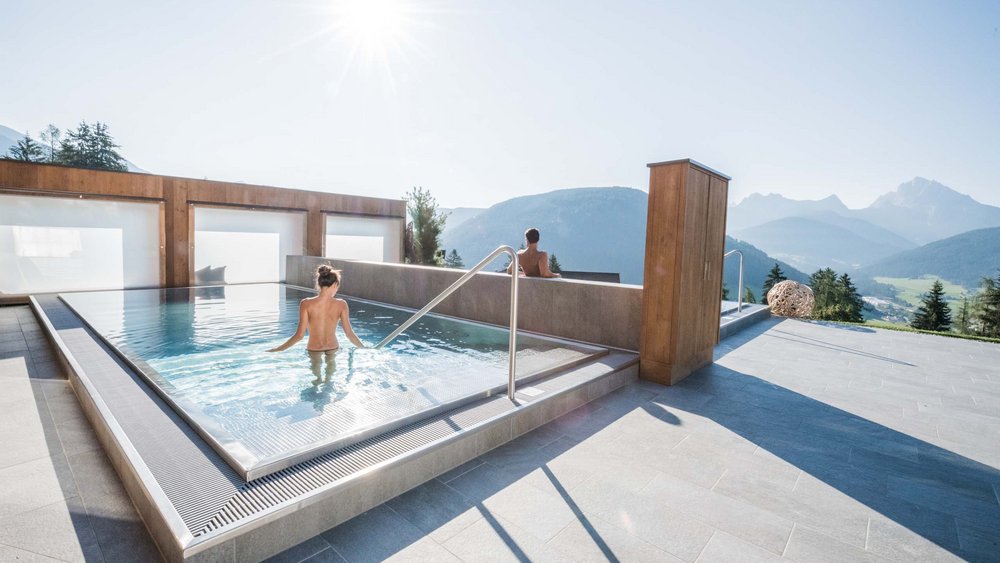 Le foto più belle dell’Alpen Tesitin Persone si rilassano in piscina esterna con vista sulle montagne al sole
