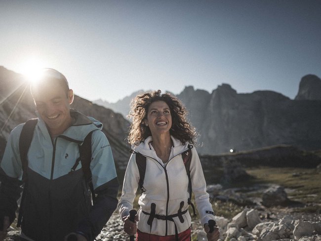 Alpen Tesitin, our hiking hotel in Val Pusteria/Pustertal Happy hikers with poles in the mountains at sunset