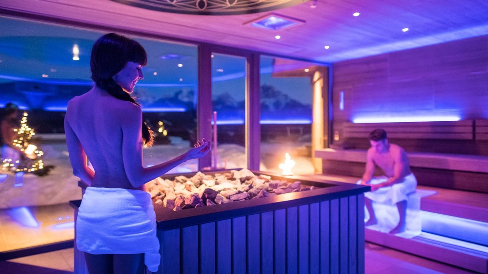 Le foto più belle dell’Alpen Tesitin Donna e uomo si rilassano in una sauna moderna con luci blu