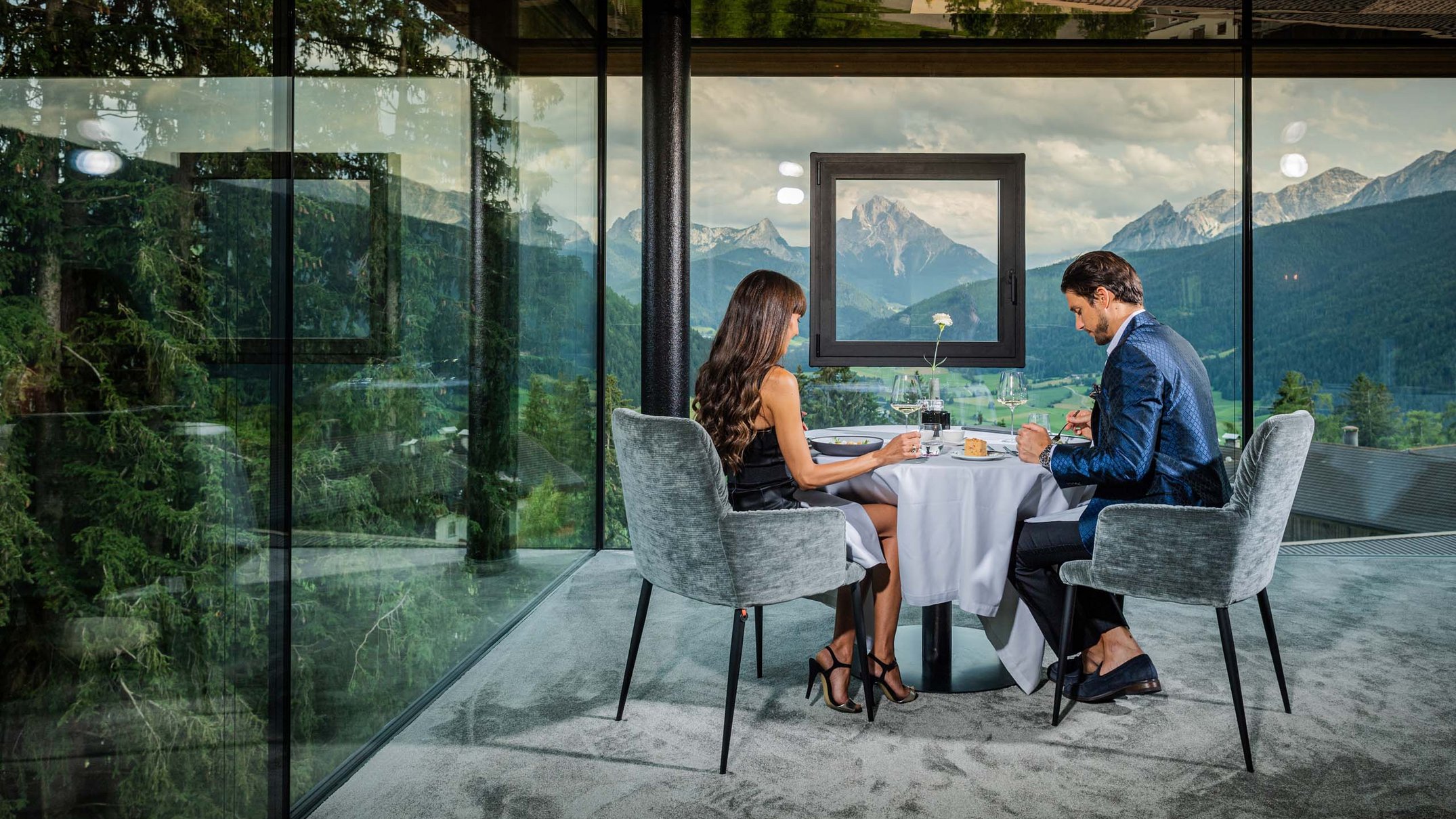 Ihr Hotel im Pustertal mit 5 Sternen: Alpen Tesitin Paar isst in modernem Glasrestaurant mit Bergblick