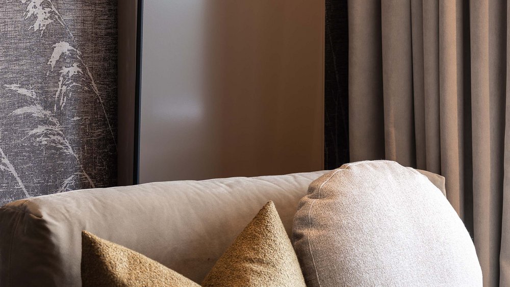 Le foto più belle dell’Alpen Tesitin Divano confortevole con due cuscini e una lampada da terra sullo sfondo