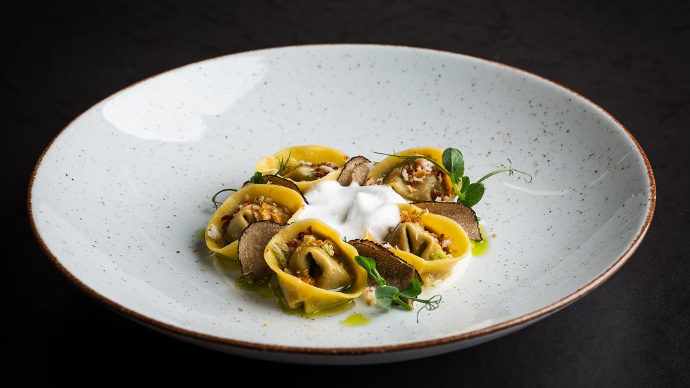 Le foto più belle dell’Alpen Tesitin Tortellini ripieni con fette di tartufo e schiuma su piatto bianco