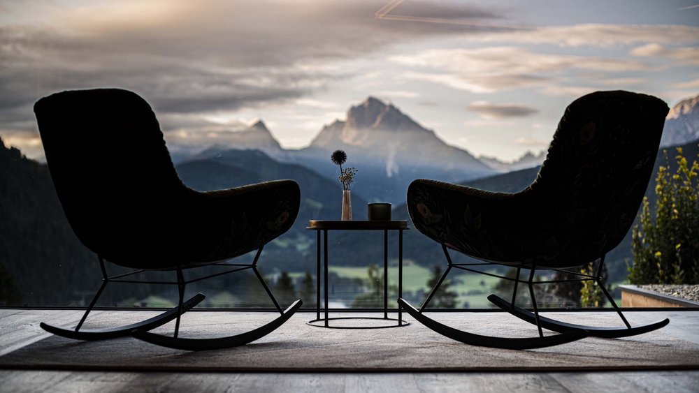Le foto più belle dell’Alpen Tesitin Due sedie a dondolo con vista sulle montagne al tramonto