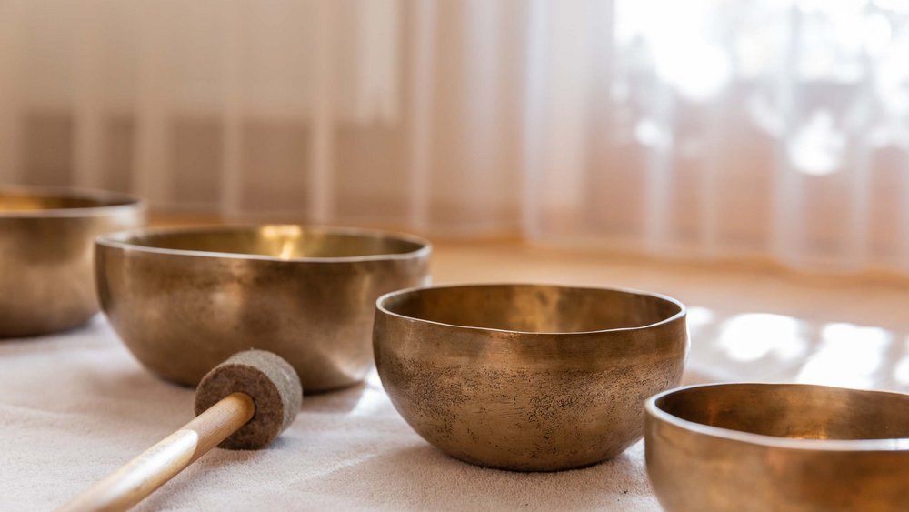 Pictures of our Alpen Tesitin Several Tibetan singing bowls on light fabric with a wooden mallet