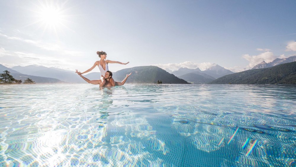 Le foto più belle dell’Alpen Tesitin Coppia che si gode il sole in piscina con vista sulle montagne