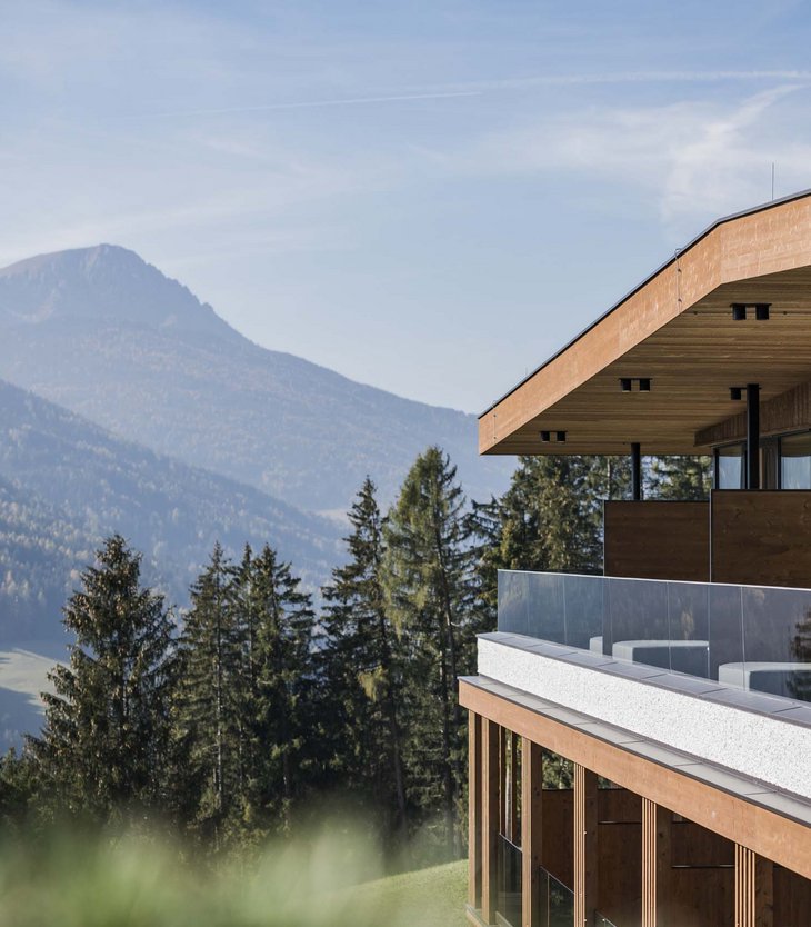 Ihr Hotel im Pustertal mit 5 Sternen: Alpen Tesitin Moderner hölzerner Balkon mit Glasgeländer mit Blick auf Wald und Berge