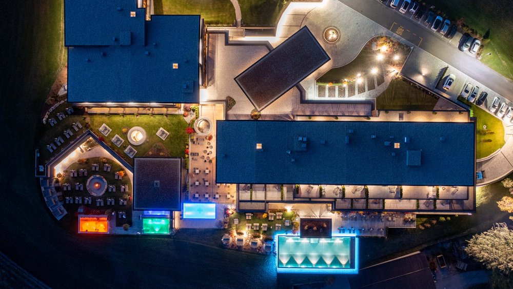 Le foto più belle dell’Alpen Tesitin Veduta aerea di un hotel illuminato con piscine e aree esterne di notte