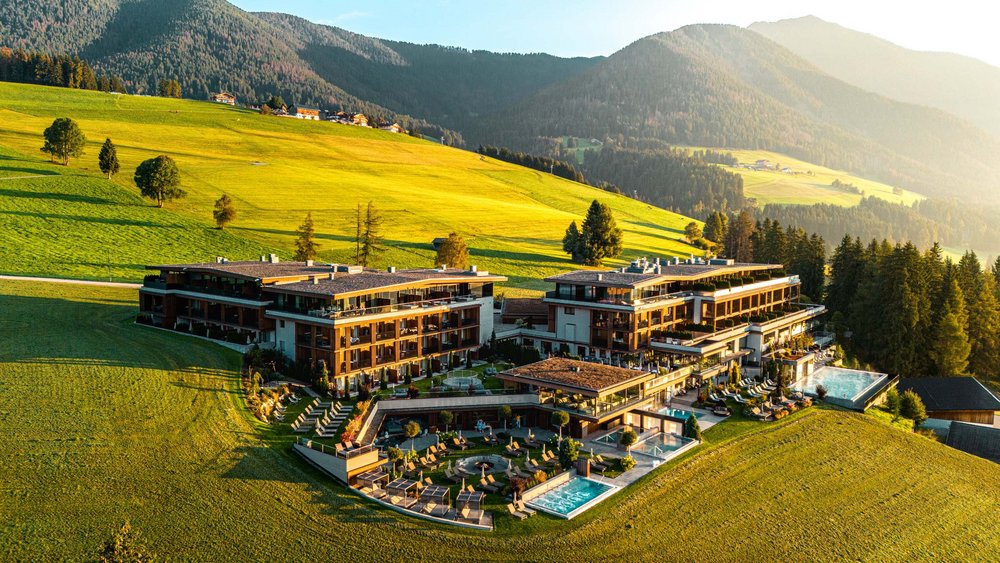 Le foto più belle dell’Alpen Tesitin Hotel di lusso nella campagna alpina verde con piscine all'aperto al tramonto