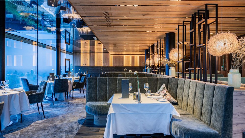 Le foto più belle dell’Alpen Tesitin Interno di un ristorante moderno con tavoli eleganti e comode sedute