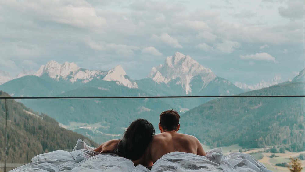 Le foto più belle dell’Alpen Tesitin Coppia a letto con vista sulle montagne e cielo nuvoloso