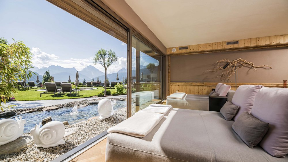 Le foto più belle dell’Alpen Tesitin Lounge confortevole con vista su giardino, montagne e fontana d'acqua