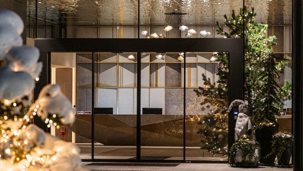 Le foto più belle dell’Alpen Tesitin Ingresso con decorazioni natalizie e albero illuminato in edificio moderno