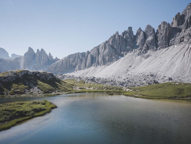 Alpen Tesitin, our hiking hotel in Val Pusteria/Pustertal Mountain lake with green meadow and rocky peaks in the background