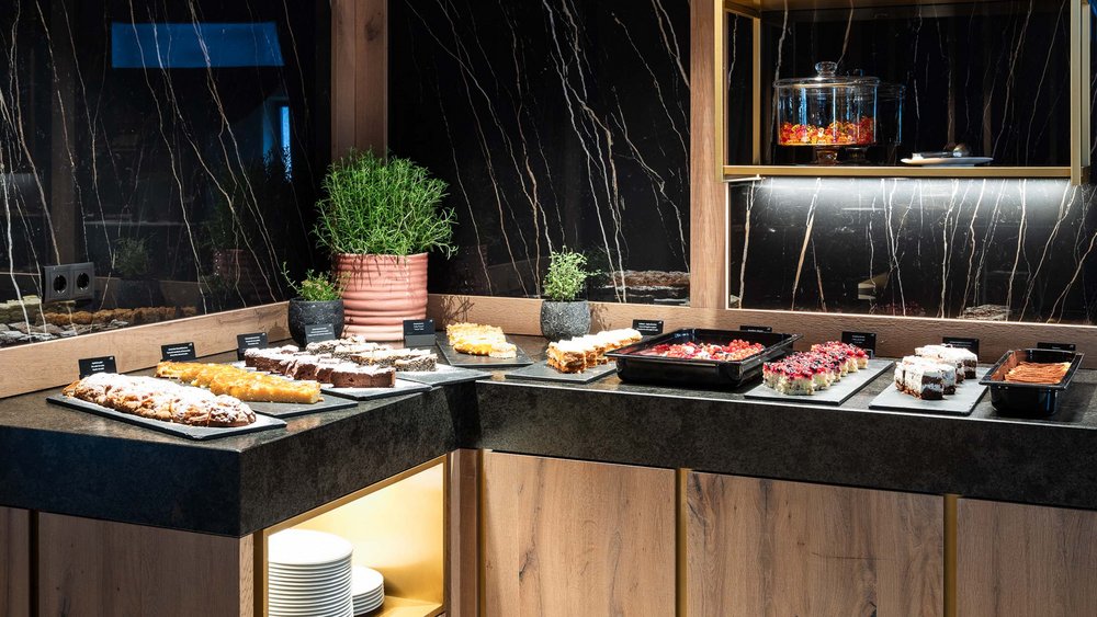 Le foto più belle dell’Alpen Tesitin Angolo buffet con torte assortite e piante su piano in marmo nero