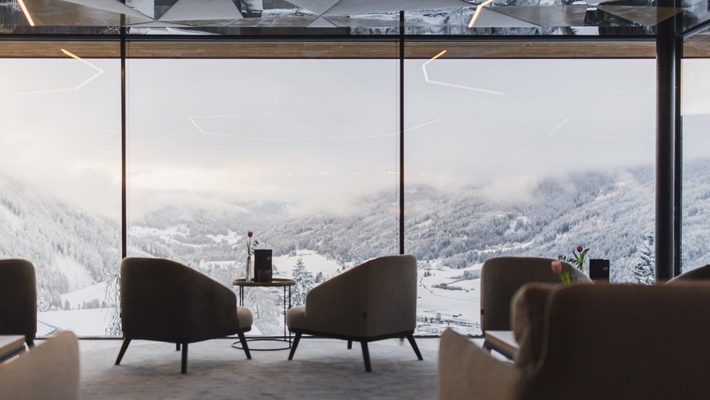 Le foto più belle dell’Alpen Tesitin Lounge moderna con poltrone e vista sulle montagne innevate