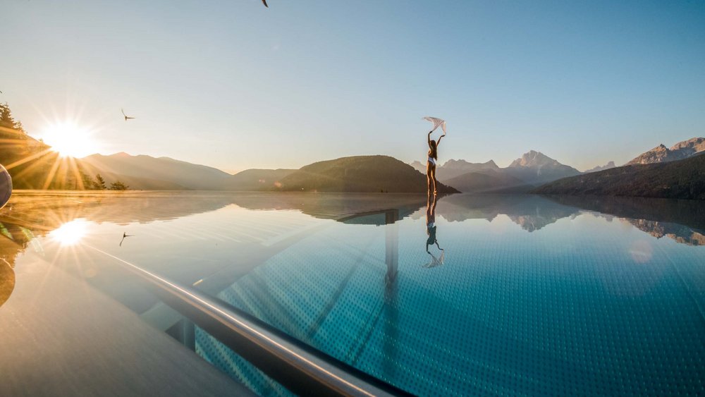 Le foto più belle dell’Alpen Tesitin Donna che balla vicino a piscina con vista sulle montagne al tramonto