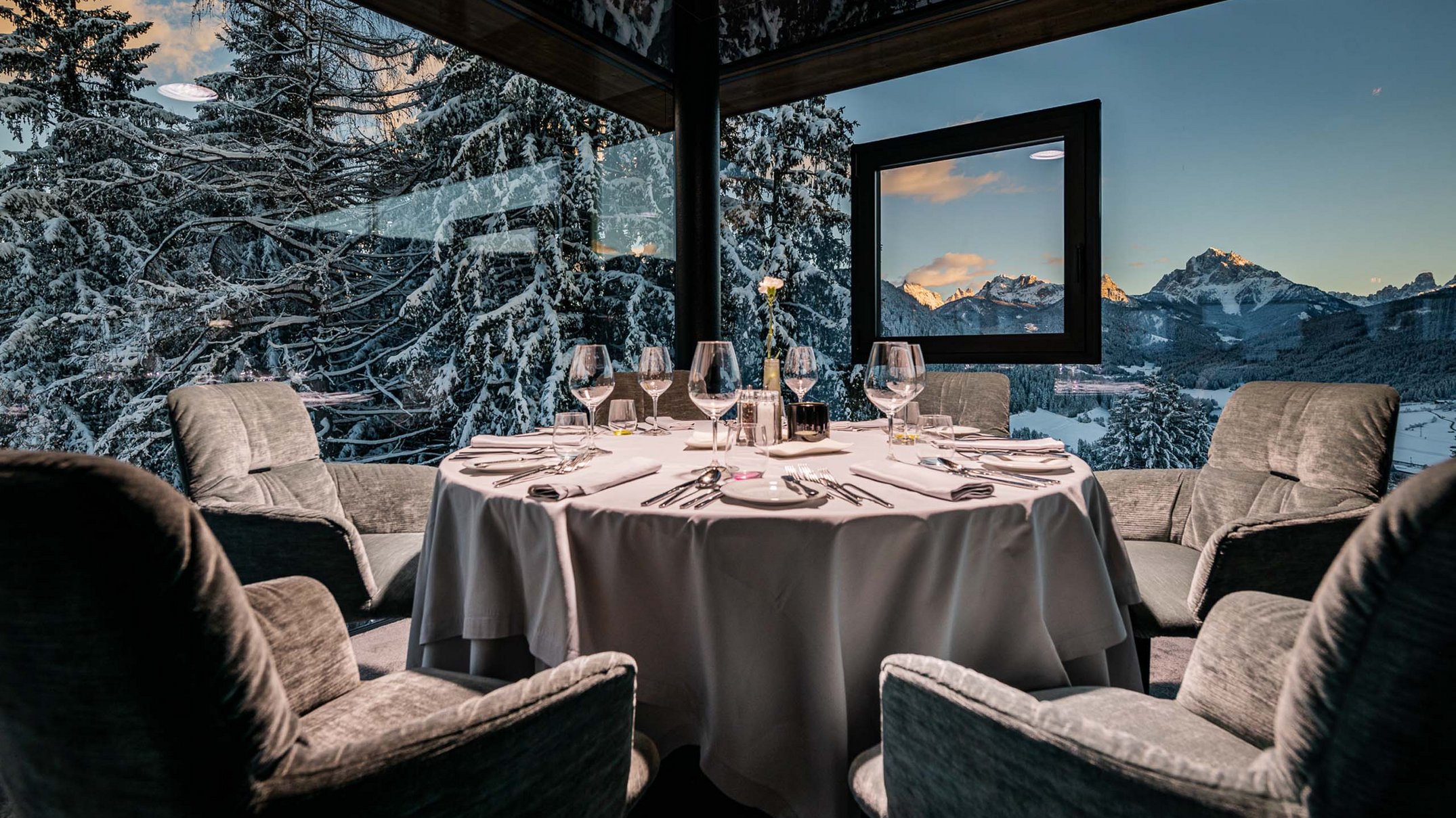 Ihr Hotel im Pustertal mit 5 Sternen: Alpen Tesitin Elegantes Esszimmer mit runder Tafel und Blick auf verschneite Berge