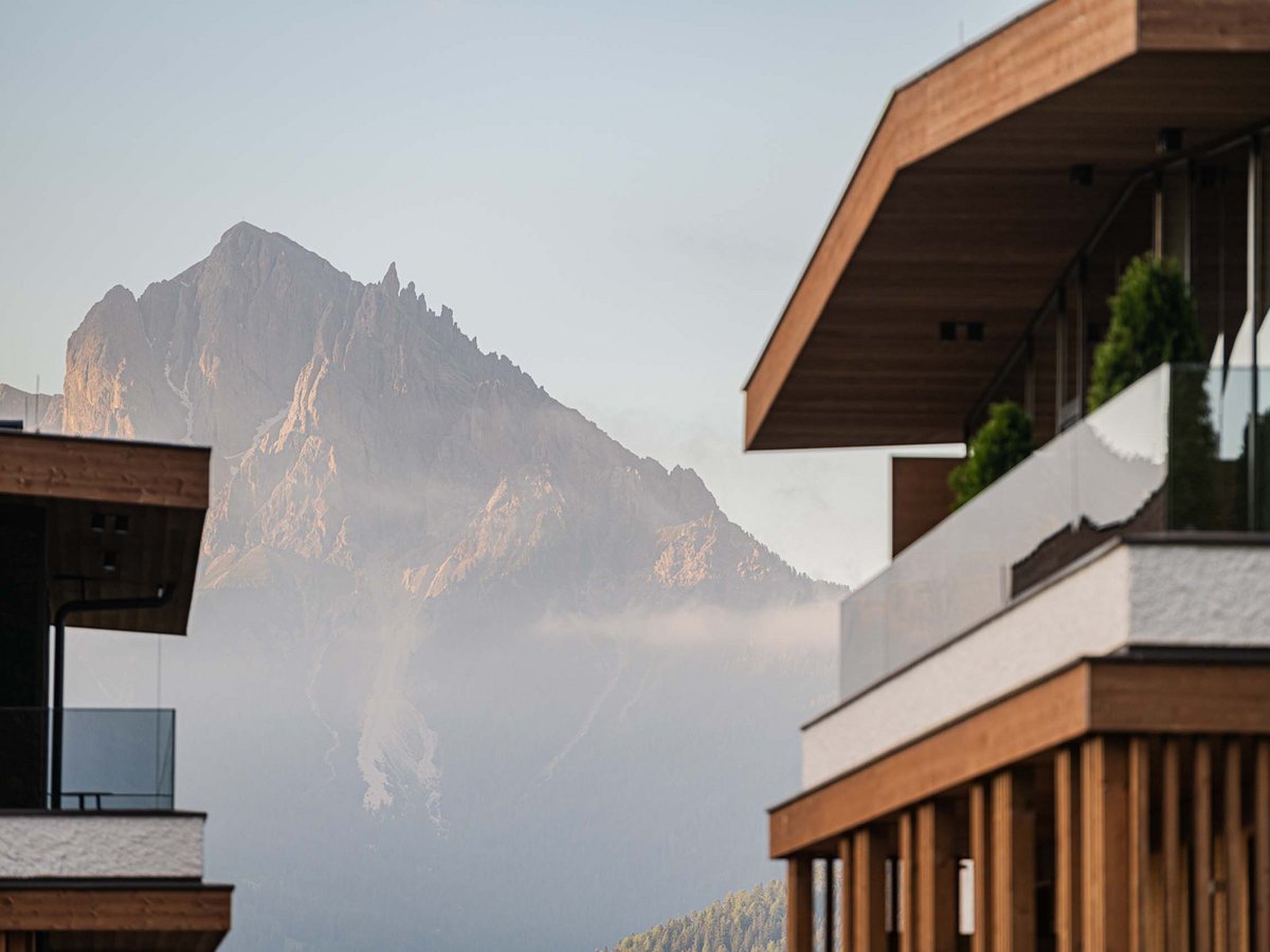 Ihr Hotel im Pustertal mit 5 Sternen: Alpen Tesitin Moderner Gebäudefront mit Berg im Hintergrund bei klarem Himmel