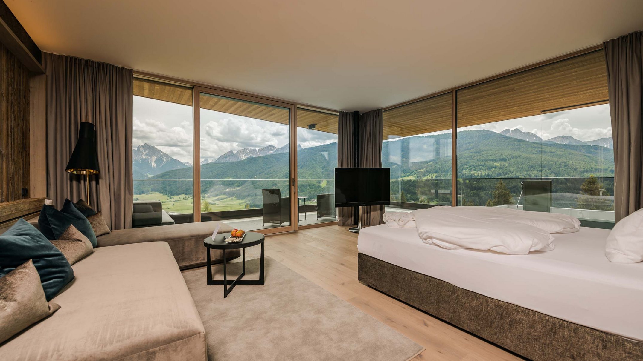 Ihr Hotel im Pustertal mit 5 Sternen: Alpen Tesitin Moderne Hotellobby mit Sofa, Bett und Panoramablick auf Berge