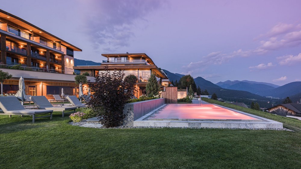 Le foto più belle dell’Alpen Tesitin Complesso alberghiero moderno con piscina esterna illuminata e vista sulle montagne al crepuscolo