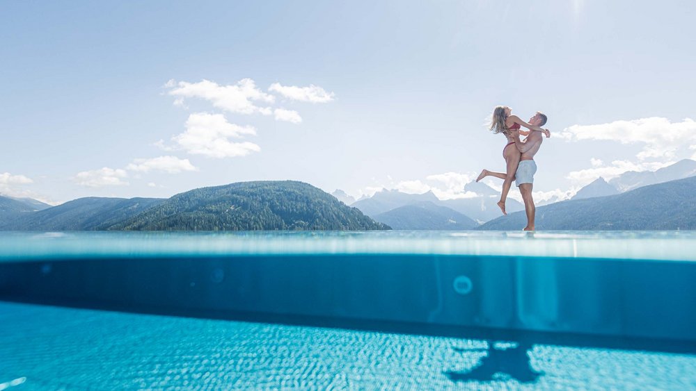 Le foto più belle dell’Alpen Tesitin Coppia al bordo di una piscina a sfioro con vista sulle montagne al sole