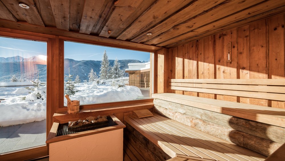 Le foto più belle dell’Alpen Tesitin Sauna in legno con grande finestra e vista sulle montagne innevate