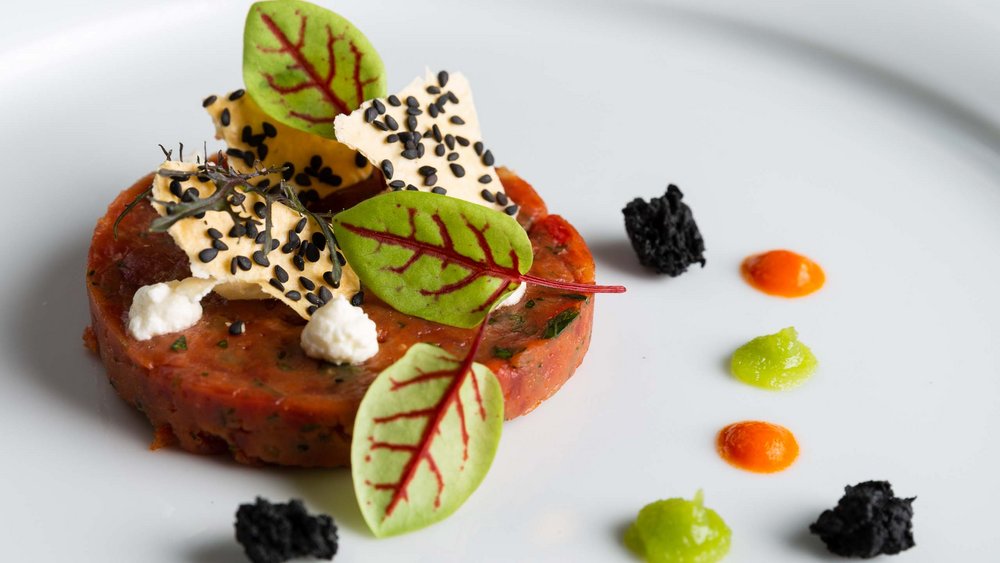 Le foto più belle dell’Alpen Tesitin Piatto gourmet con foglie, sesamo e salse colorate su piatto bianco