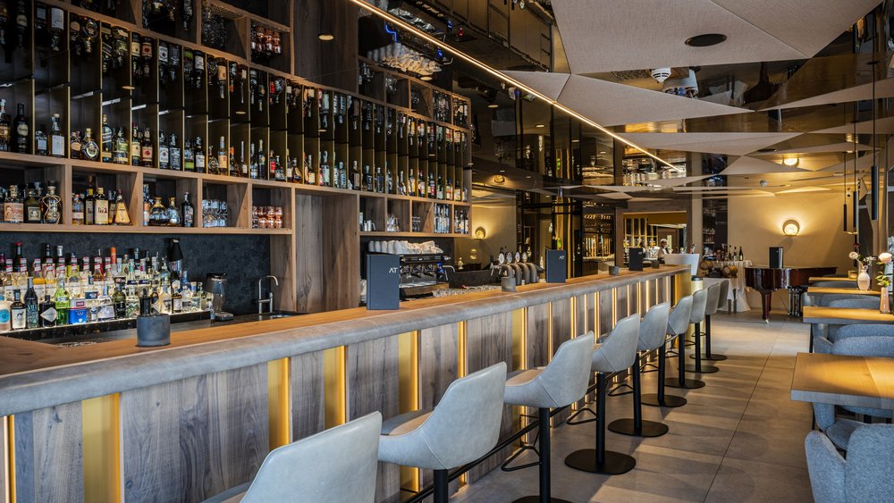 Le foto più belle dell’Alpen Tesitin Bar moderna con mobili in legno e pelle e bancone illuminato