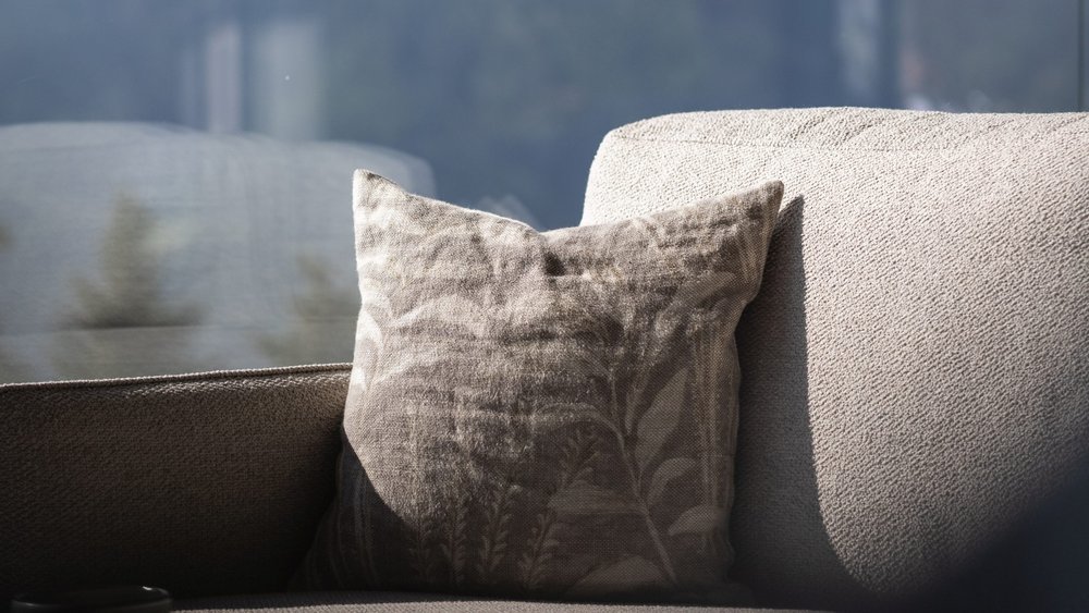 Le foto più belle dell’Alpen Tesitin Cuscino illuminato su divano grigio davanti a finestra con vista sulle montagne