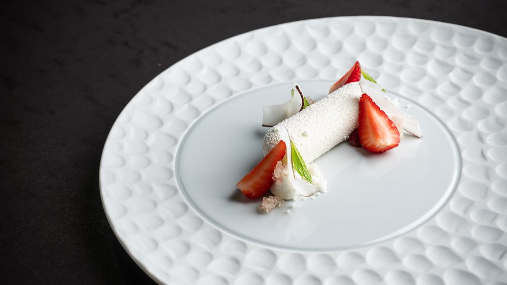 Le foto più belle dell’Alpen Tesitin Dessert raffinato con fragole, cocco e menta su piatto bianco