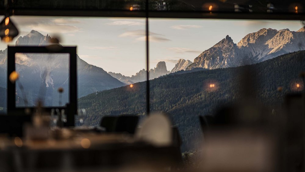 Le foto più belle dell’Alpen Tesitin Panorama montano con foresta visto dall'interno di un ristorante