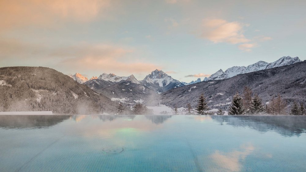 Pictures of our Alpen Tesitin Heated pool with snowy mountain view at sunset