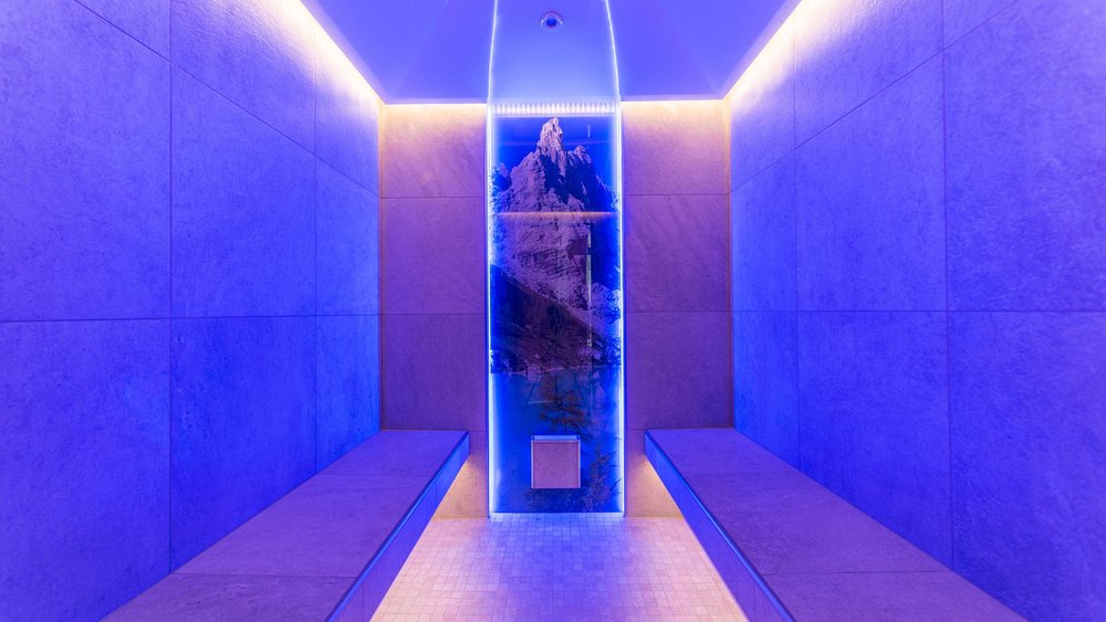 Le foto più belle dell’Alpen Tesitin Stanza moderna con illuminazione blu e immagine di montagne su pannello retroilluminato