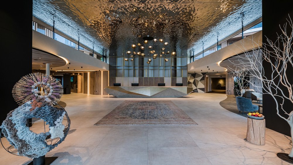 Le foto più belle dell’Alpen Tesitin Ingresso elegante con soffitto artistico e sculture moderne